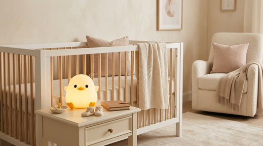 Glowing duck-shaped nursery night light displayed on a bedside table beside a crib