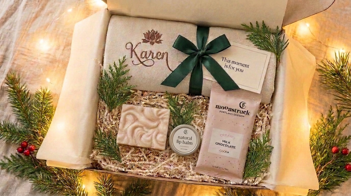 Holiday gift box with a towel personalized with Karen, green ribbon, swirled soap, natural lip balm and Moonstruck milk chocolate cocoa.